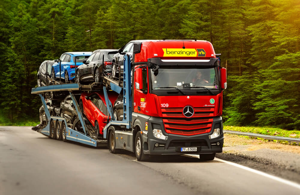 A car transporter carrying several vehicles on the road